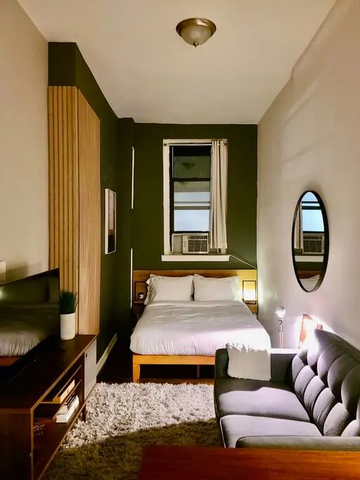 Cozy modern bedroom with sofa.