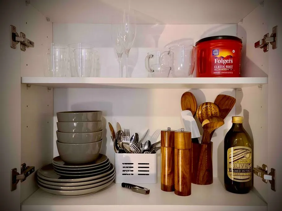Organized kitchen cabinet with utensils.