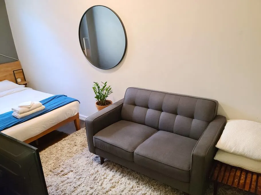 Modern cozy bedroom with sofa.