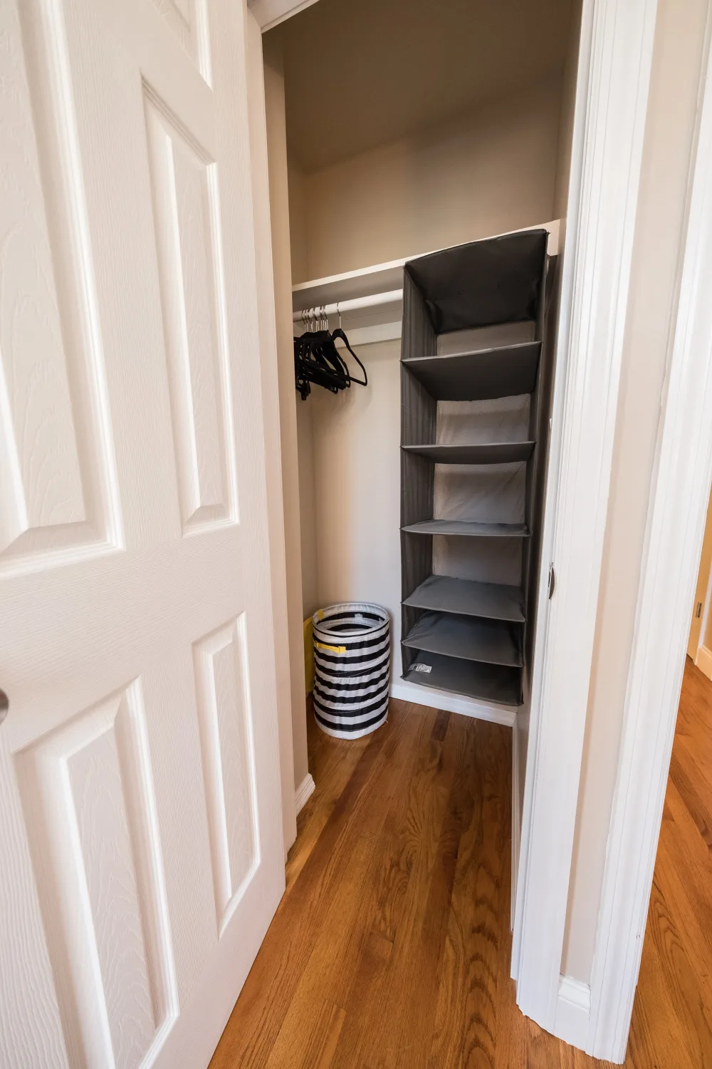 Organized closet with wooden floors.