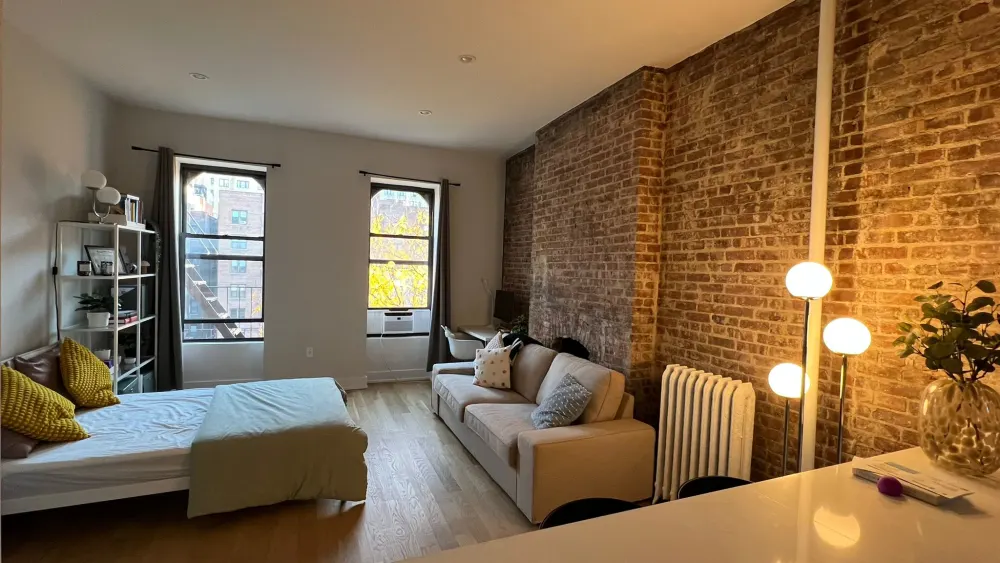 Cozy studio with brick wall.