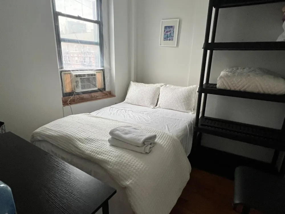 Cozy, minimalist bedroom with window.