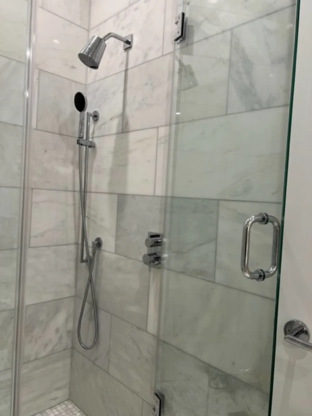 Modern shower with marble walls.
