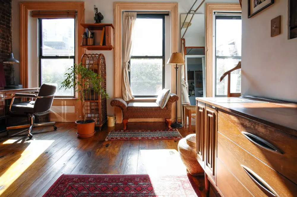 Cozy, sunlit room with furnishings.