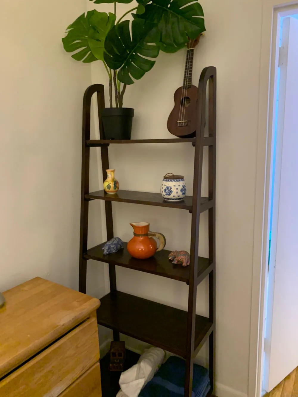 Tall wooden shelf with decorations.