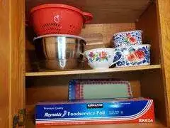 Wooden shelf holding colorful kitchenware
