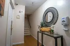 Narrow foyer with staircase, mirror