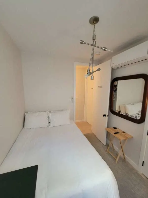 Cozy white bedroom with mirror