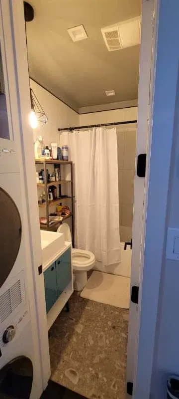 Compact bathroom with shower curtain