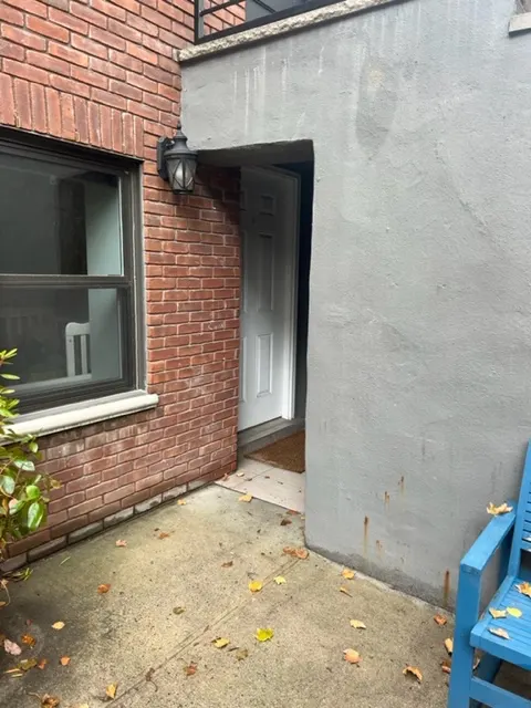 Brick wall, doorway, and blue chair.