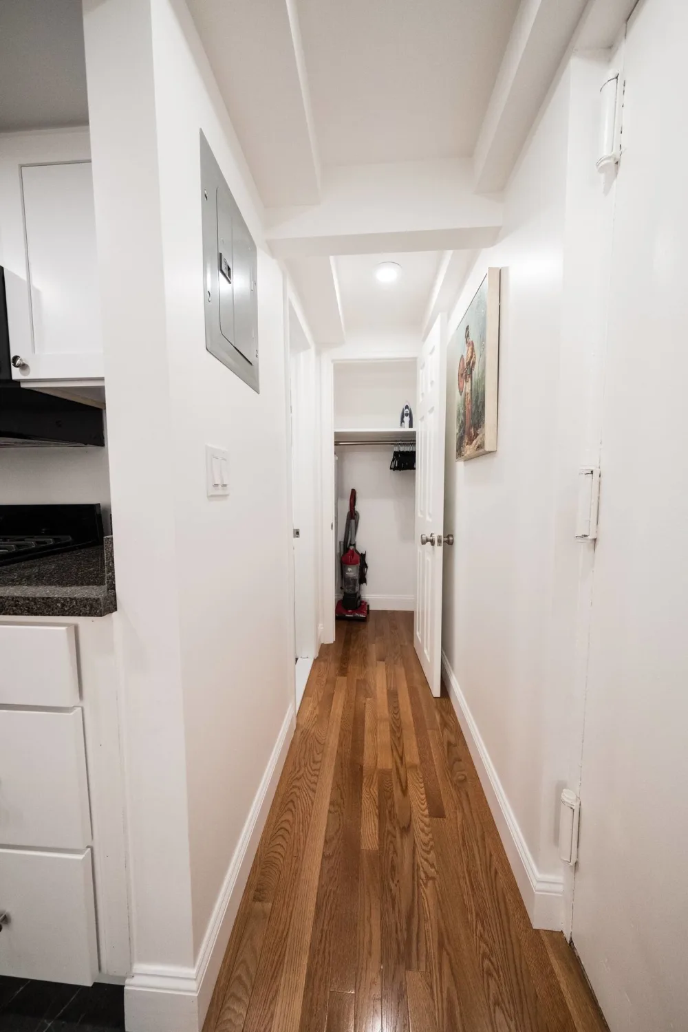 Narrow hallway with hardwood floor.