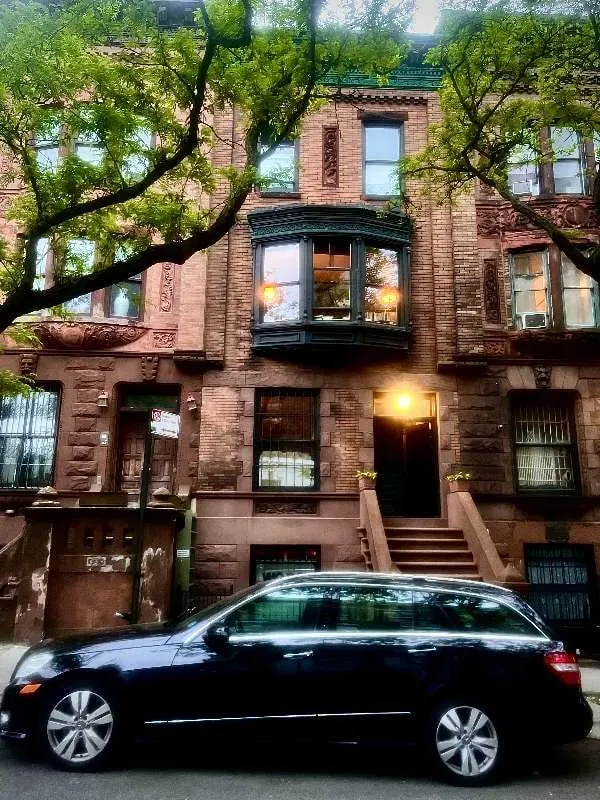 Tree-lined brownstone with parked car