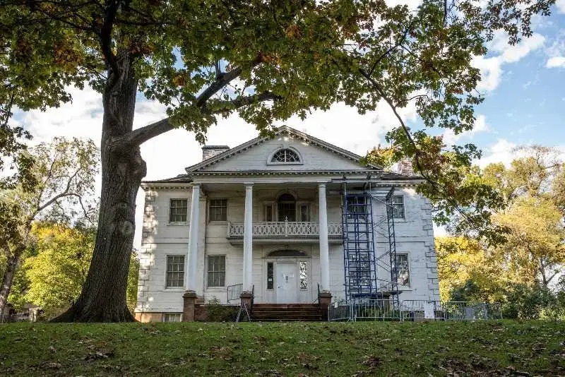 White colonial mansion with scaffolding