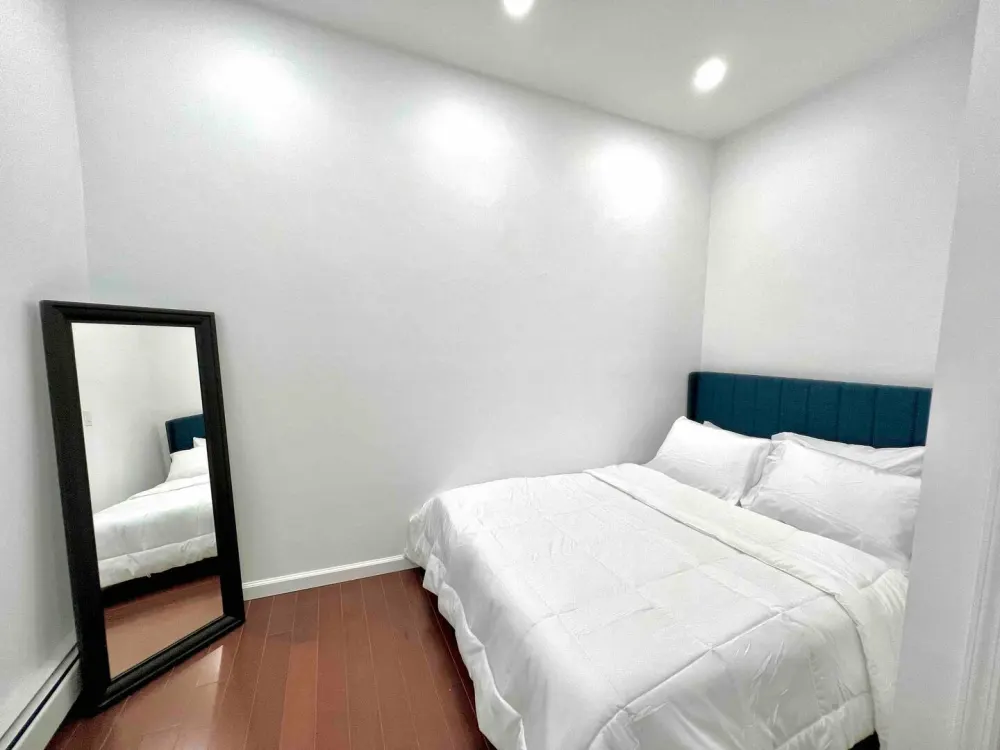 Minimalist bedroom with a mirror.