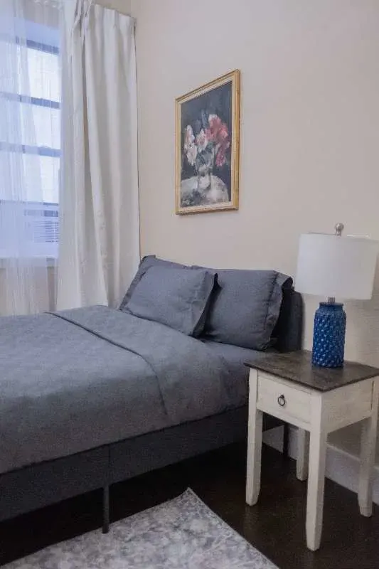 Cozy gray bed with nightstand