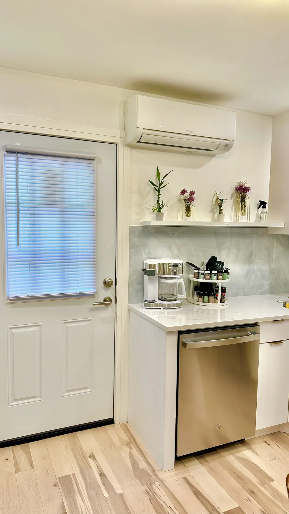 Modern, minimalist kitchenette with door.
