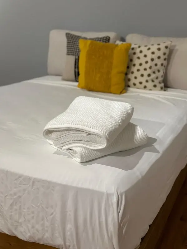 Folded towels on inviting bed