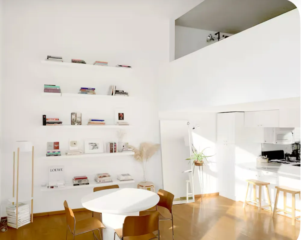 Bright minimalist dining area, bookshelves
