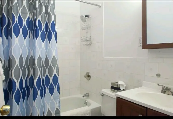 Clean bathroom with patterned curtain.