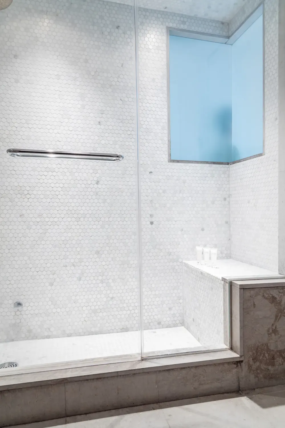 Modern white tiled shower area.