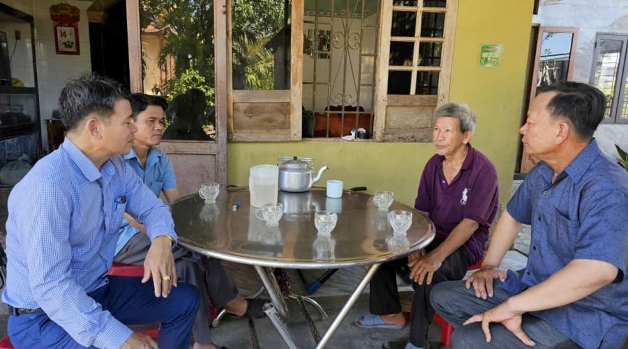 Cán bộ cấp ủy và Ban công tác Mặt trận thôn Kim Long tiếp xúc, vận động người dân di dời mồ mả phục vụ dự án - Ảnh: T.T