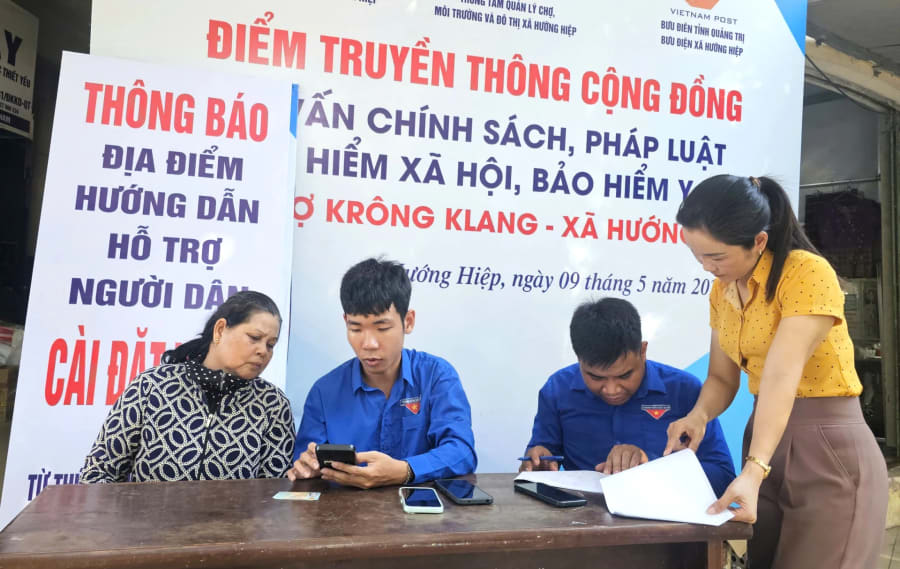 Thành viên Tổ công nghệ số cộng đồng xã Hướng Hiệp hướng dẫn người dân kích hoạt tài khoản định danh mức độ 2 - Ảnh: T.P