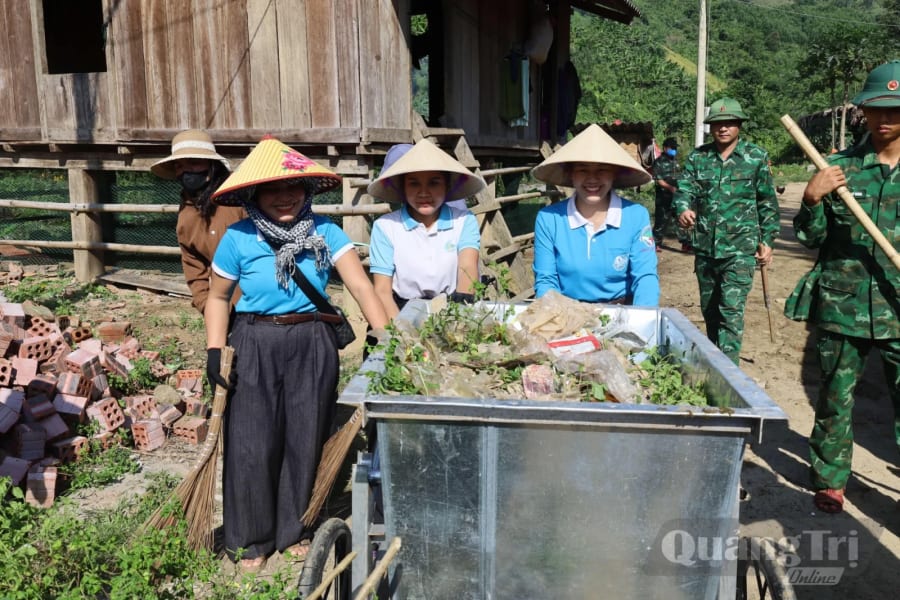 Hội LHPN xã Dân Hóa cùng cán bộ, chiến sĩ Bộ đội Biên phòng thu gom rác thải, vệ sinh khuôn viên nhà ở tại bản Lòm- K. Chăm, xã Dân Hóa, góp phần giữ gìn môi trường bản làng sạch đẹp - Ảnh: Q.N.