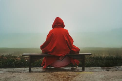 Street photography featuring a man in red clothing, creating a striking contrast in the urban environment