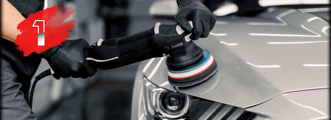 Professional car detailing with polisher on red car