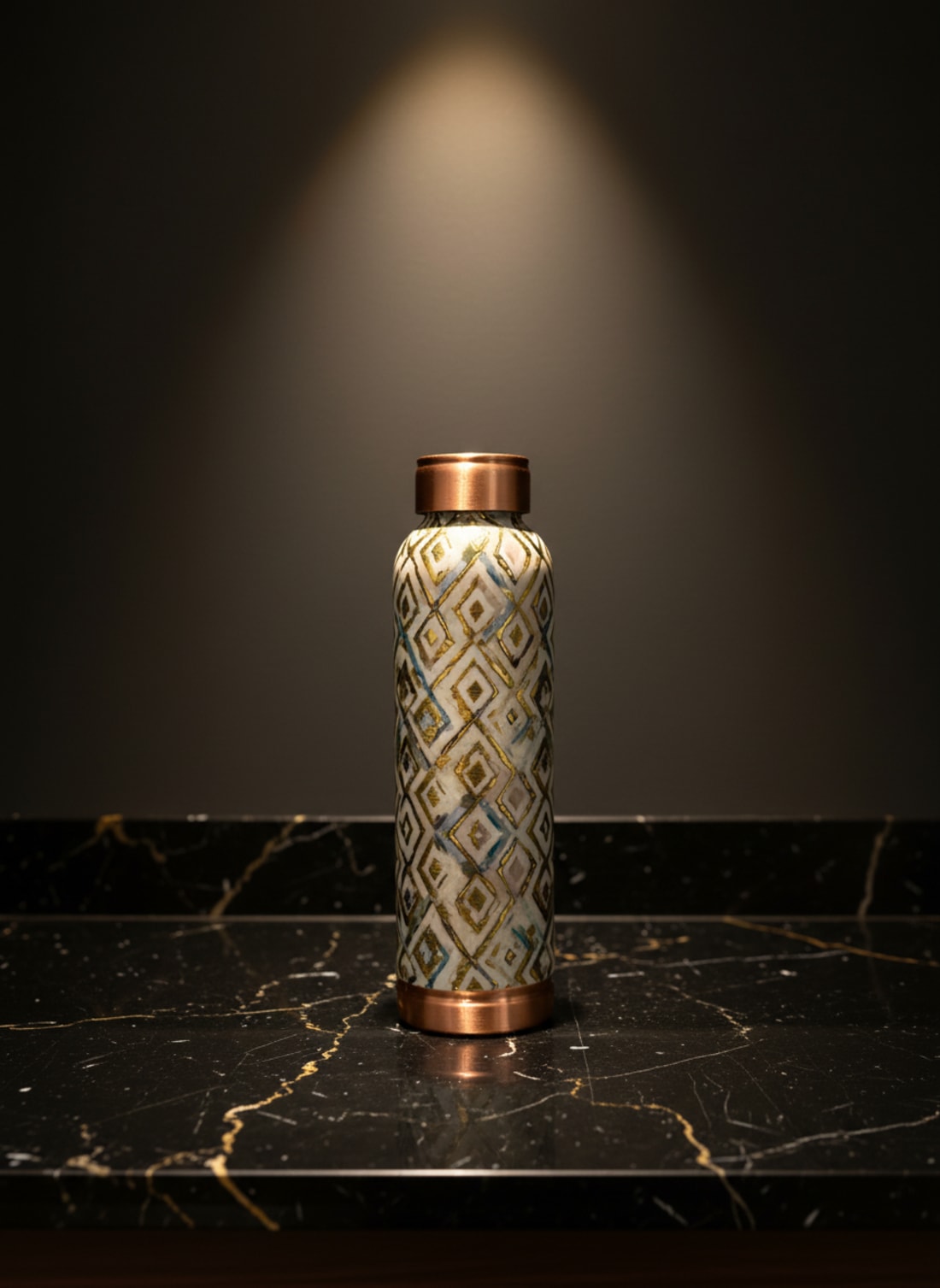 Handcrafted designer copper water bottle with elegant gold and white geometric diamond print on a premium marble surface