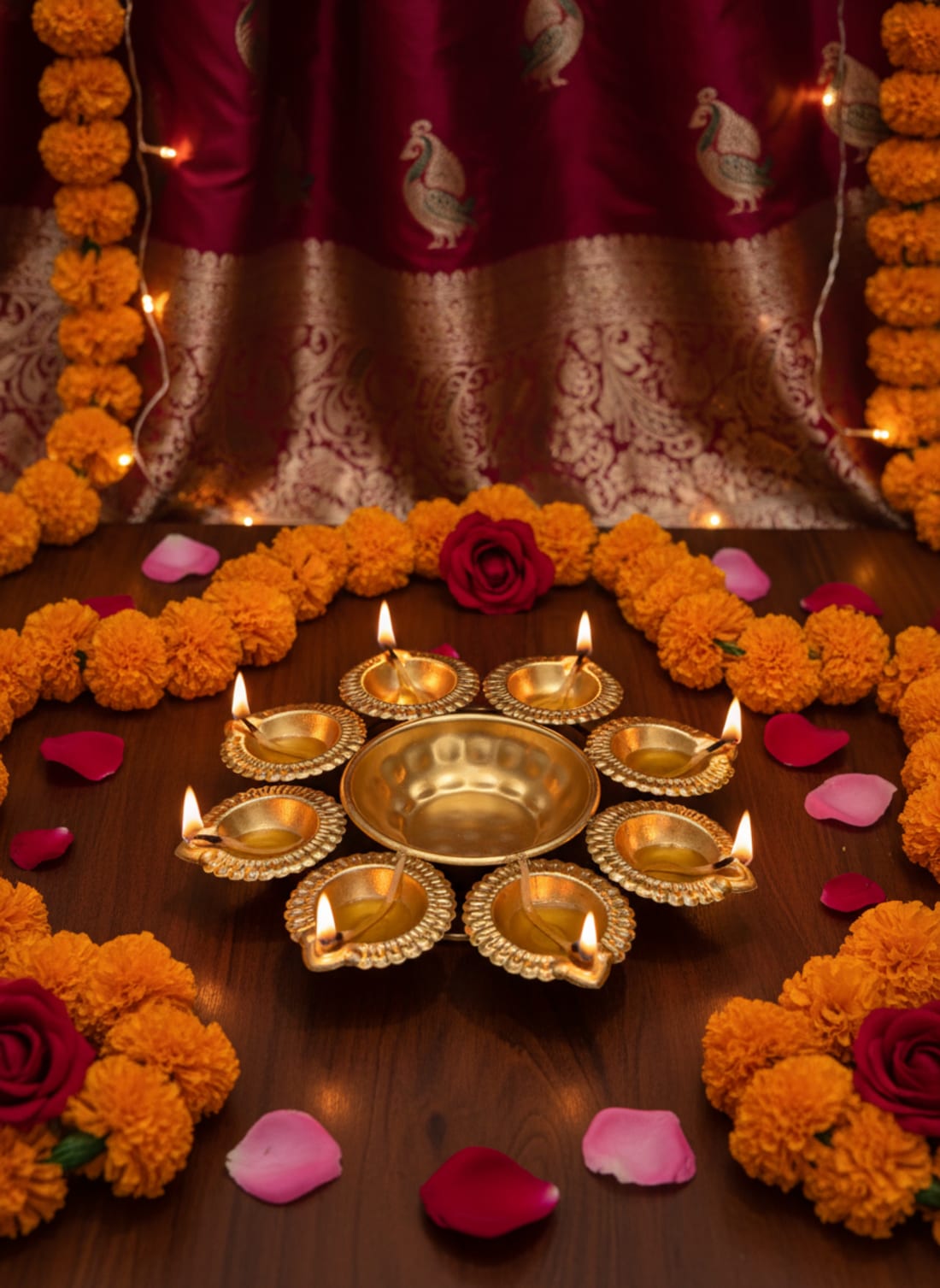 Elegant brass multi-wick diya oil lamp arranged with marigold garlands and rose petals for festive decoration.