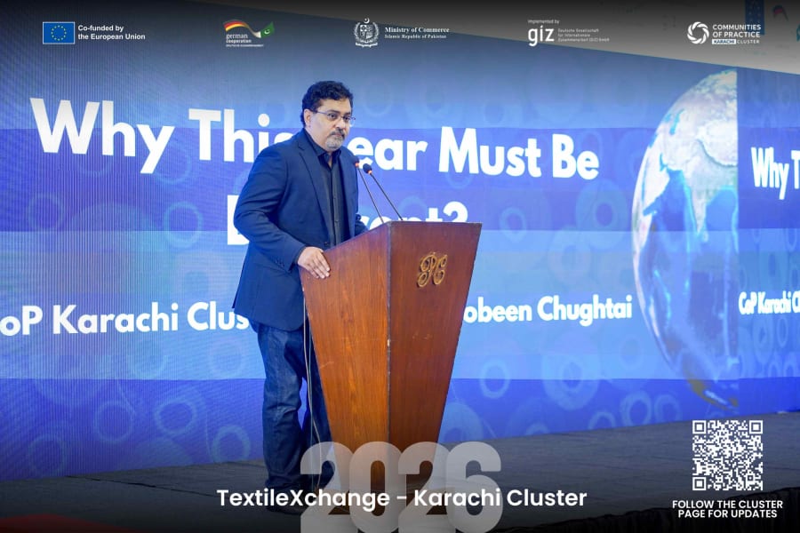 Mobeen Chughtai speaking at a podium during TextileXchange 2026, with the conference screen showing the session theme behind him.