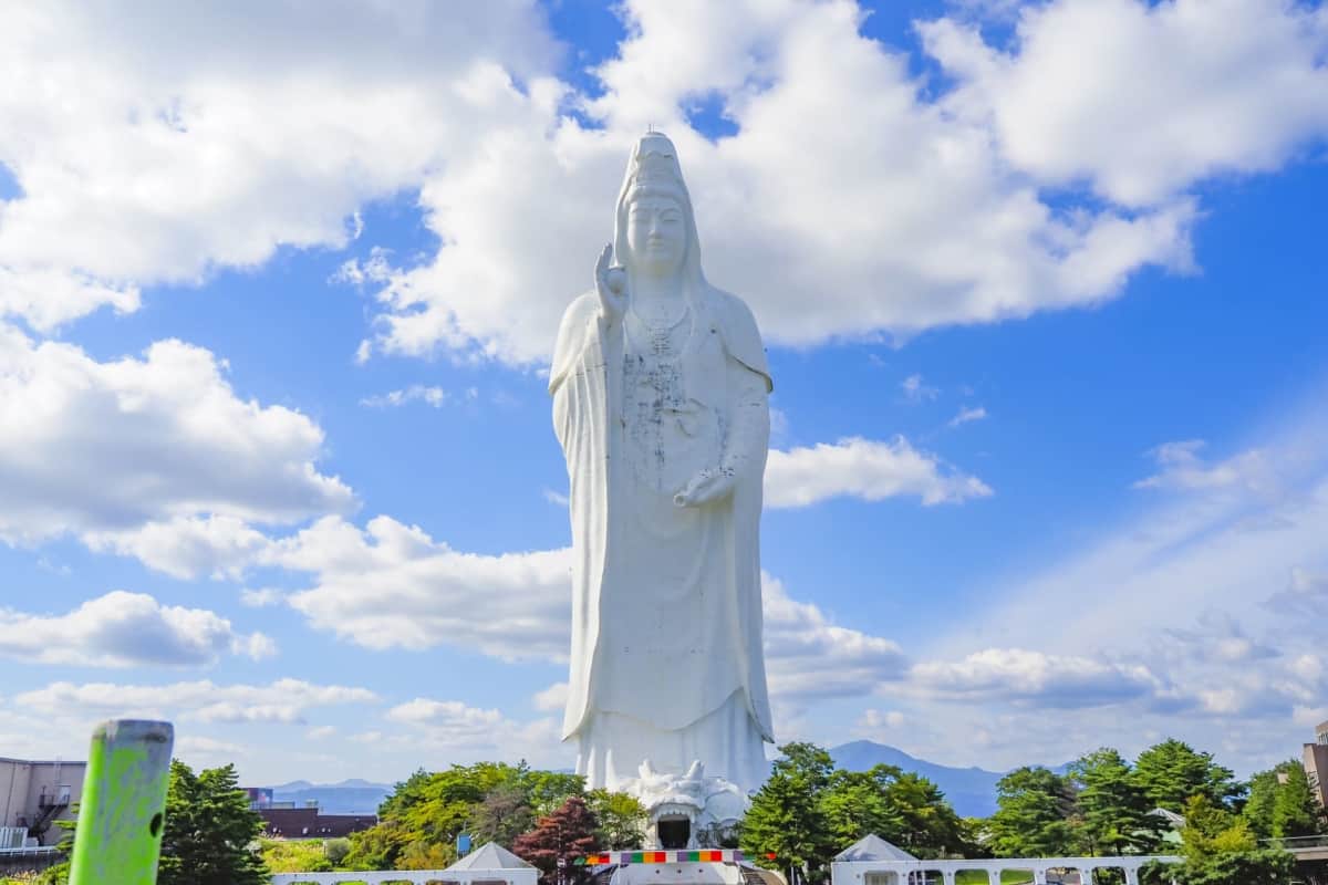 Sendai Daikannon, a towering white Buddhist statue in Sendai, Japan, featuring temple grounds, panoramic city views, interior Buddhist statues, spiral staircases, and peaceful spiritual spaces at Daikanmitsuji Temple.