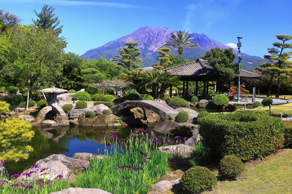 Historic samurai garden featuring landscaped grounds, stone paths, and views of an active volcano