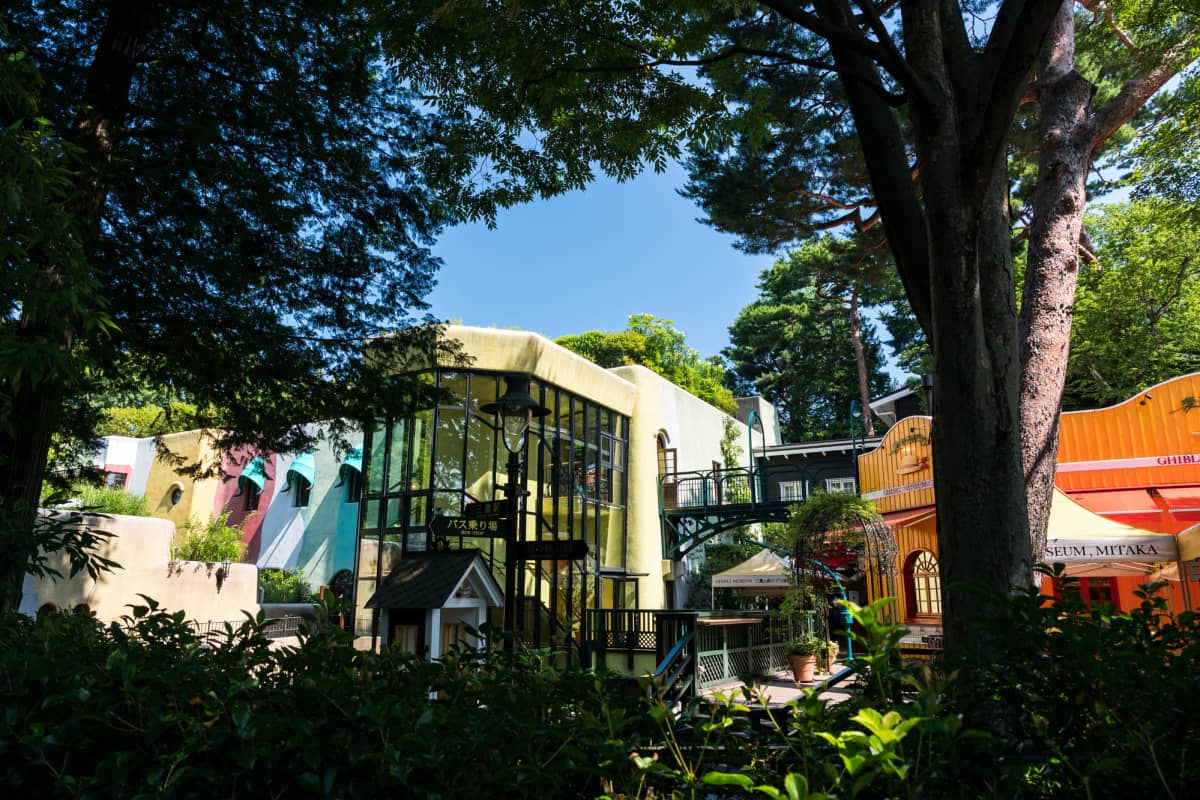Charming exterior and artistic details of the Ghibli Museum surrounded by lush greenery.