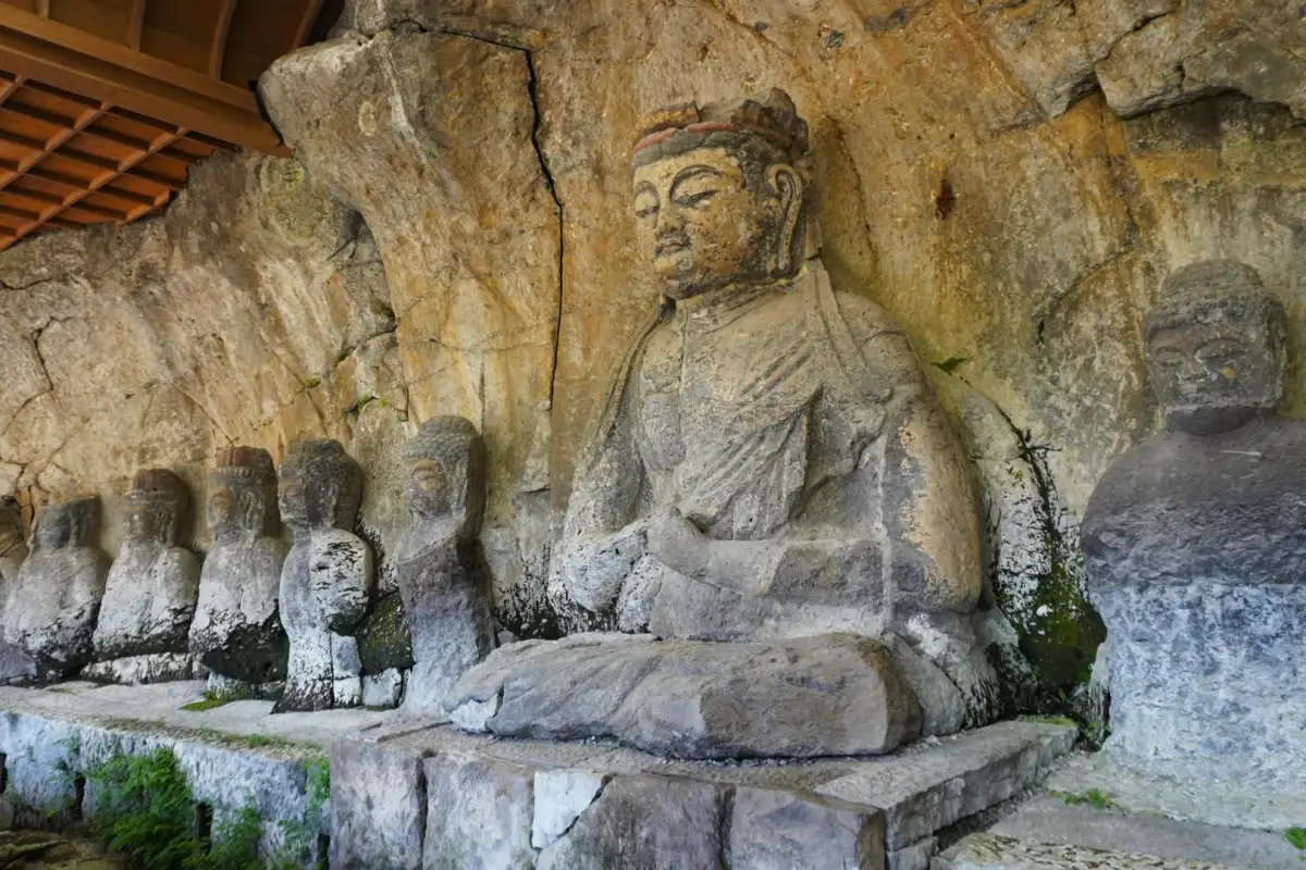 pathways of the Usuki Stone Buddhas, where centuries-old Buddhist carvings emerge from moss-covered rock walls in Oita, Japan.