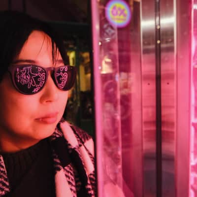 Neon lights reflect on sunglasses in Harajuku, Japan