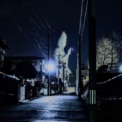 A massive white Kannon statue towers above Sendai City at Daikanmitsuji Temple, with visitors exploring the serene Buddhist interior filled with statues, spiral staircases, and panoramic viewpoints overlooking Miyagi Prefecture.
