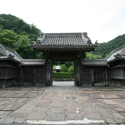 Traditional Japanese garden with Sakurajima volcano visible across Kinko Bay in Kagoshima.