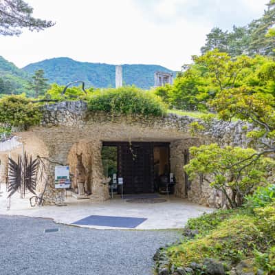 Distinctive museum architecture surrounded by lush gardens and forested landscapes in Yamanashi, Japan