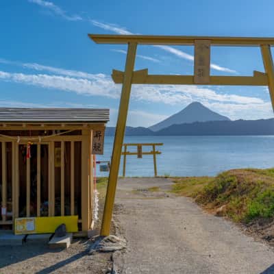 Golden torii gate overlooking Lake Ikeda and Mount Kaimon in Kagoshima