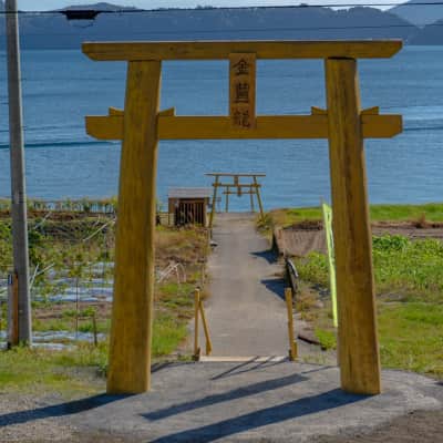 Golden torii gate overlooking Lake Ikeda and Mount Kaimon in Kagoshima