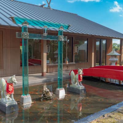 Transparent crystal torii gates and traditional red torii at a Japanese Inari shrine