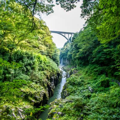 Emerald river flowing through Takachiho Gorge beneath towering basalt cliffs.