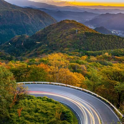 Scenic mountain road winding through the forests of Nikko with panoramic valley views.