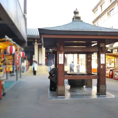 Traditional Buddhist temple grounds with worshippers and historic architecture in Tokyo.