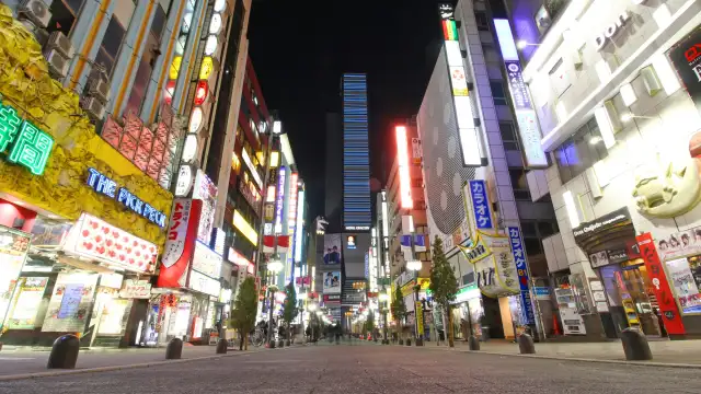 Neon-lit street in Shinjuku with the Godzilla head towering above