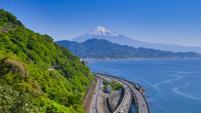 Scenic coastal landscape with highways and railway lines below Mount Fuji