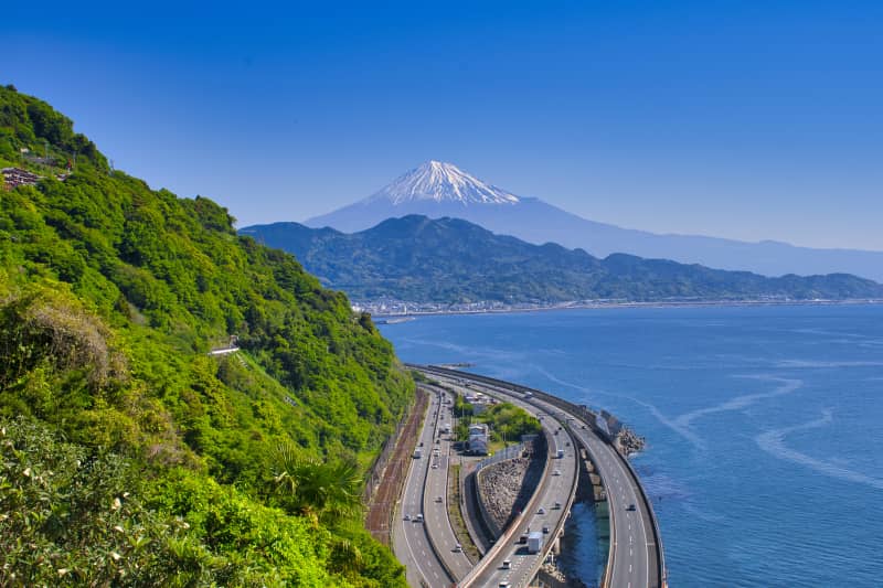Scenic coastal landscape with highways and railway lines below Mount Fuji