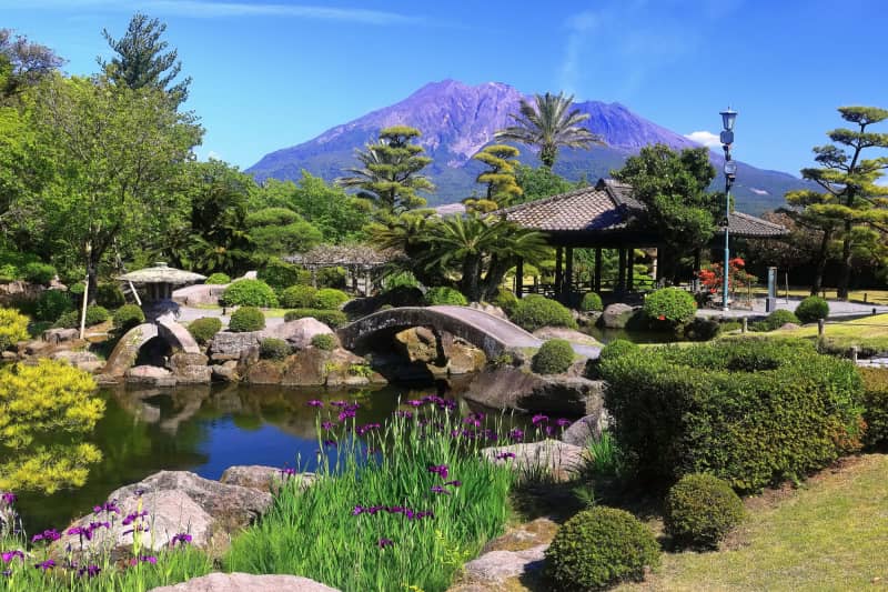 Historic samurai garden featuring landscaped grounds, stone paths, and views of an active volcano
